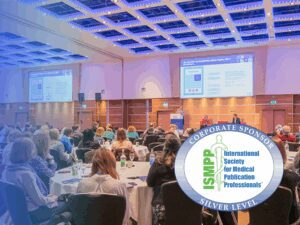 People seated in a conference room listen to a presentation; an overlay highlights the International Society for Medical Publication Professionals’ "Silver Level Corporate Sponsor" badge.