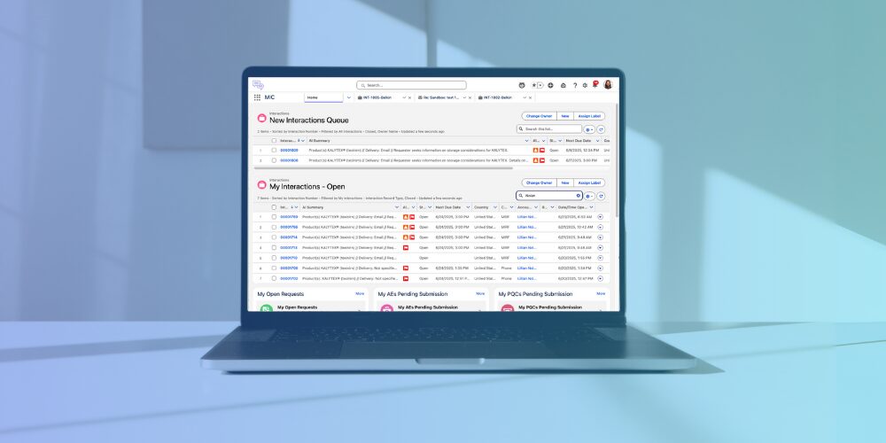 A laptop on a desk displays a dashboard with lists of interactions, requests, and submissions organized in tables.