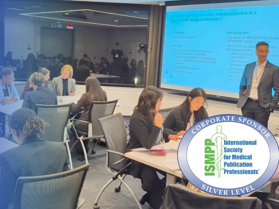 People seated at tables engage in group work in a conference room with a man standing by a projector screen. An ISMPP Silver Level Corporate Sponsor badge is displayed in the lower right corner.
